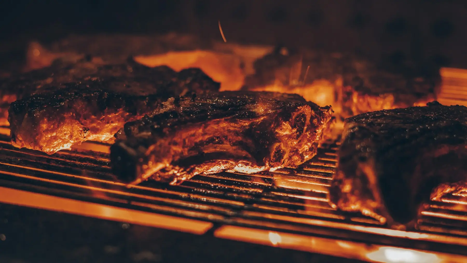 Real steaks cooking over an open charcoal flame
